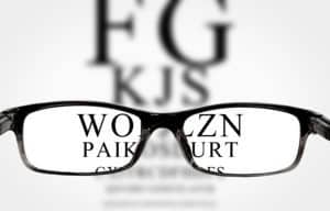 Sight test seen through eye glasses, white background isolated