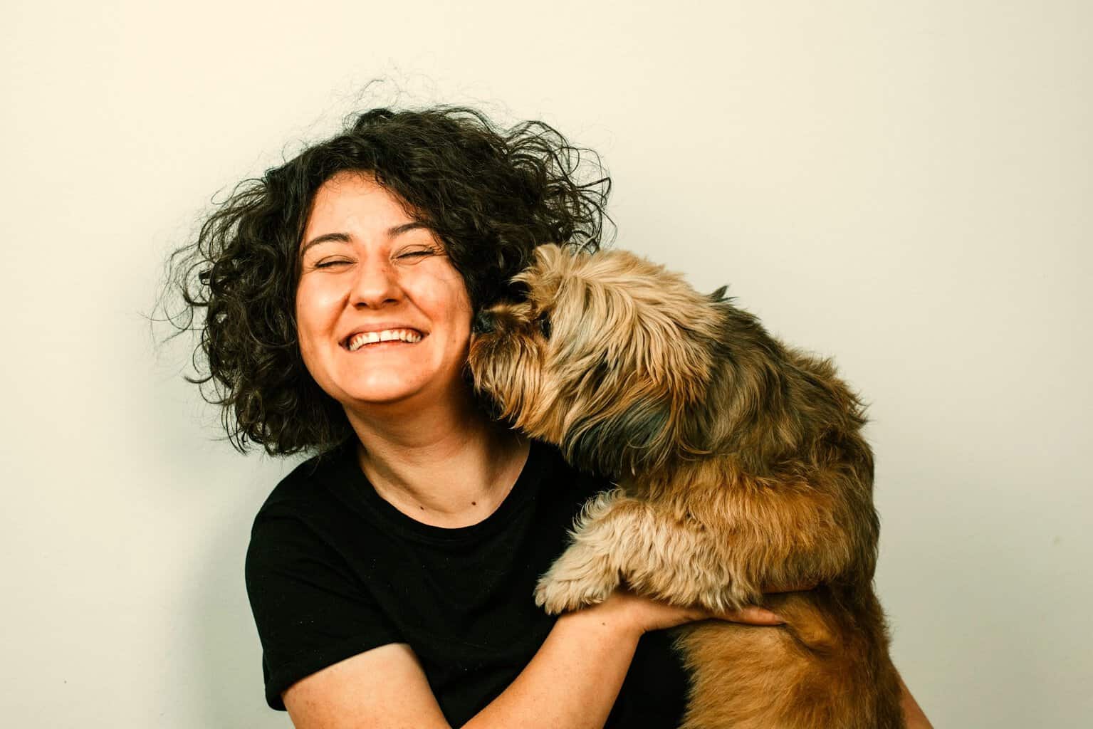 woman laughing with brwon shaggy dog